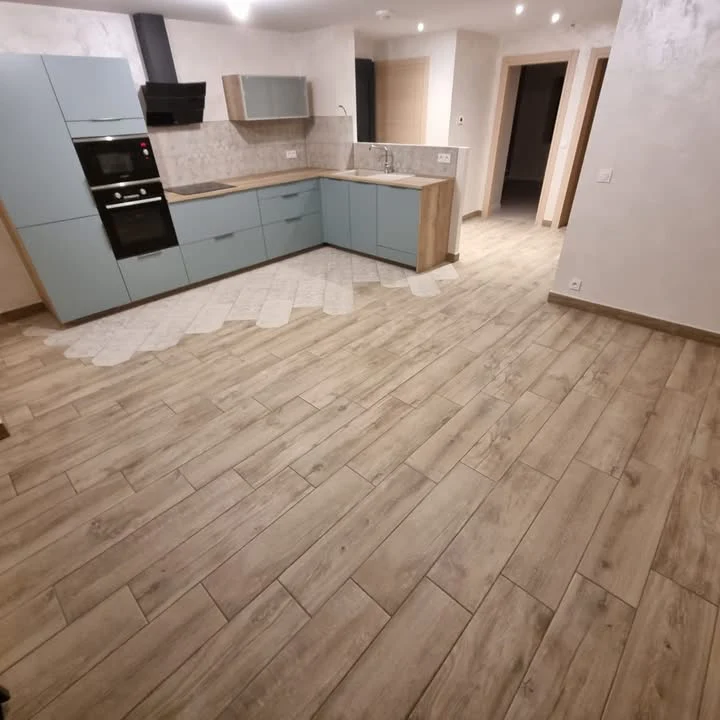 Cuisine avec sol en carrelage effet bois et transition décorative, réalisée par BTC Carrelage